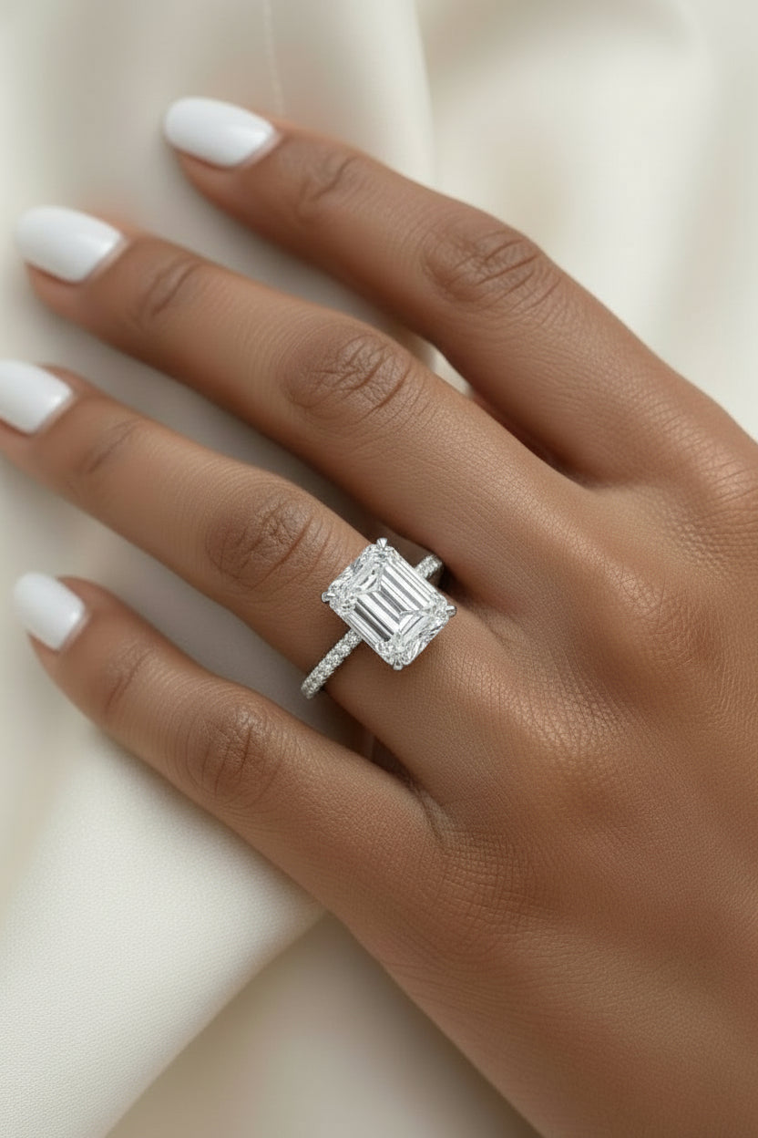 Moissanite ring with emerald cut center stone.