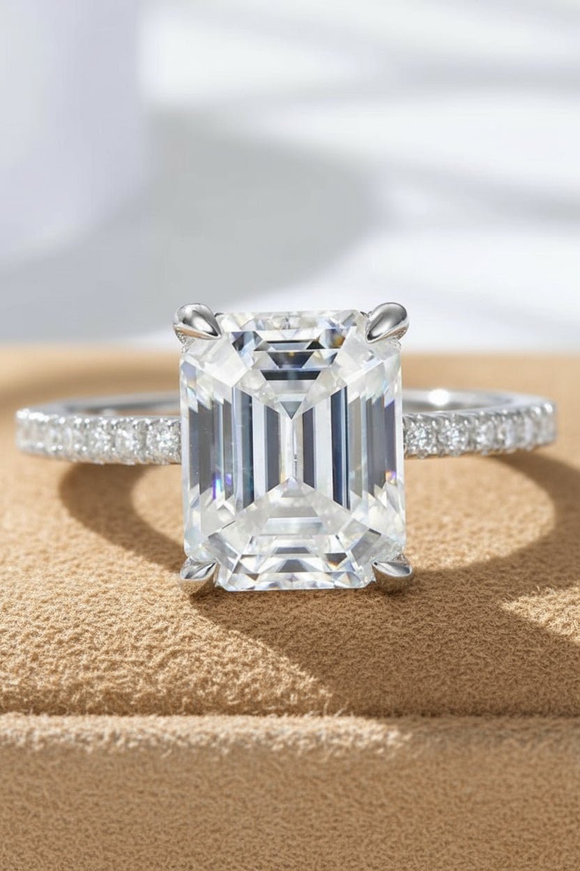 Moissanite ring with emerald cut center stone.