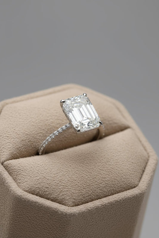 Moissanite ring with emerald cut center stone.