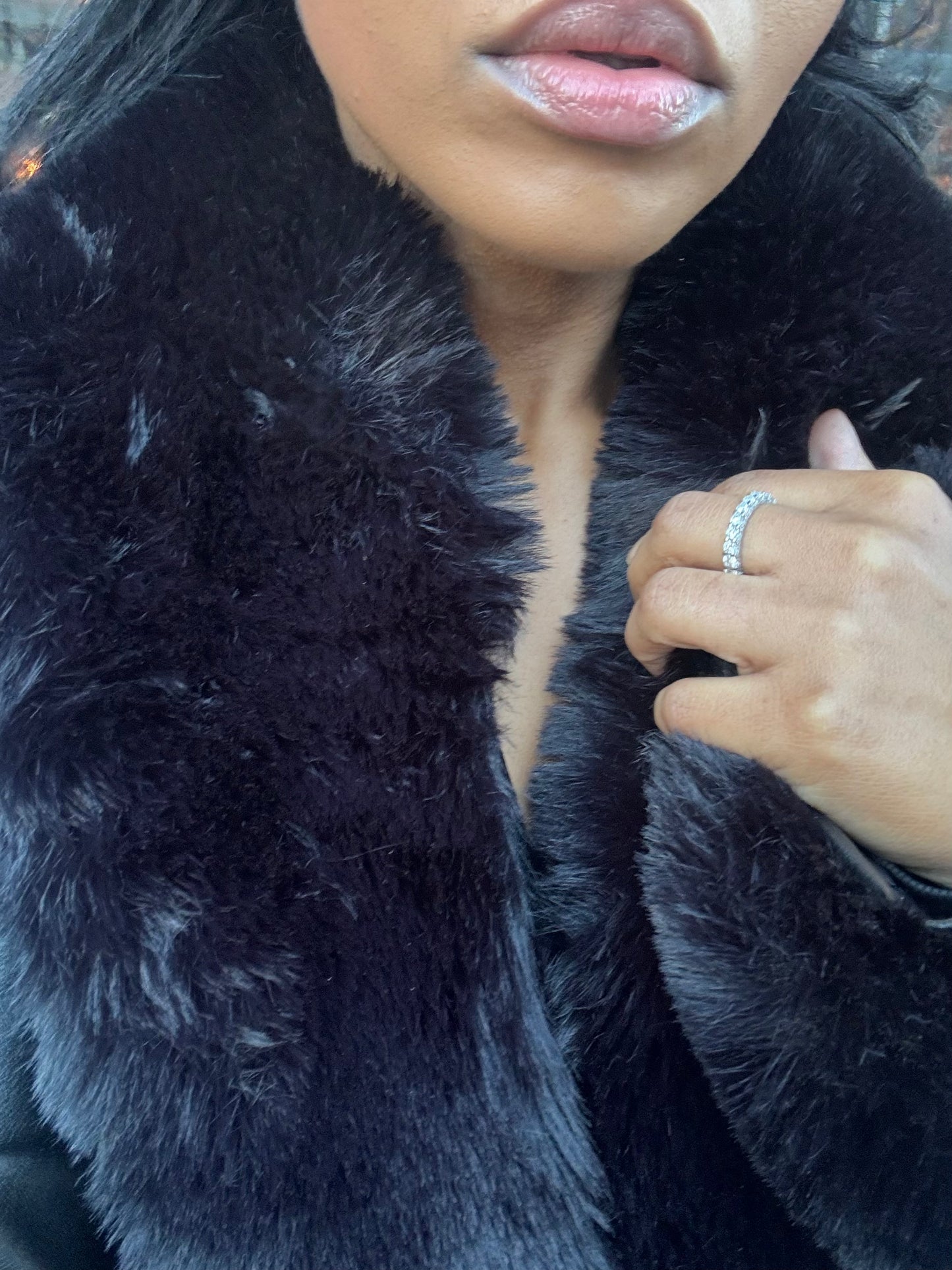 Woman wearing Frost Kiss moissanite ring with luxury fur coat