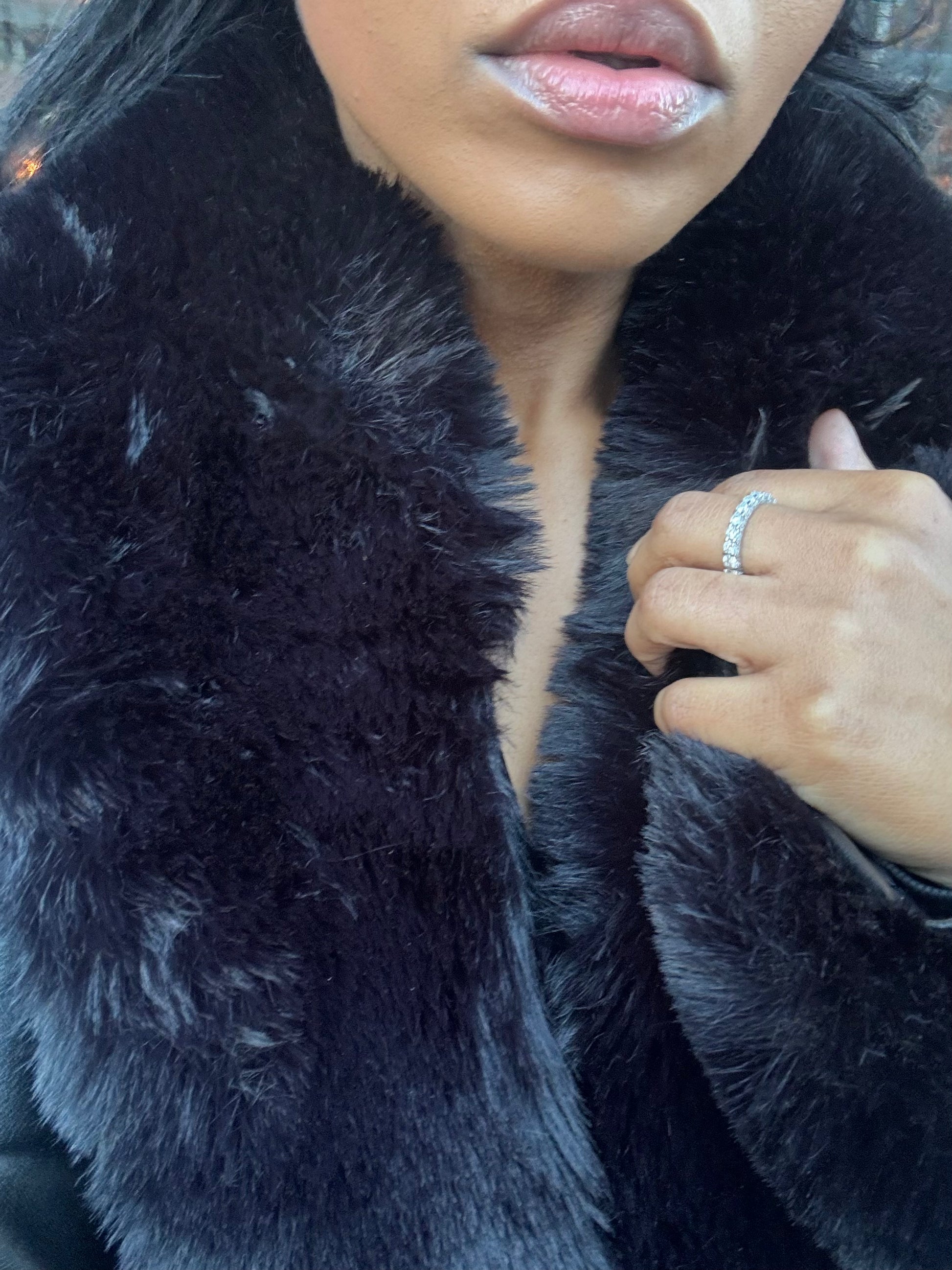 Woman wearing Frost Kiss moissanite ring with luxury fur coat