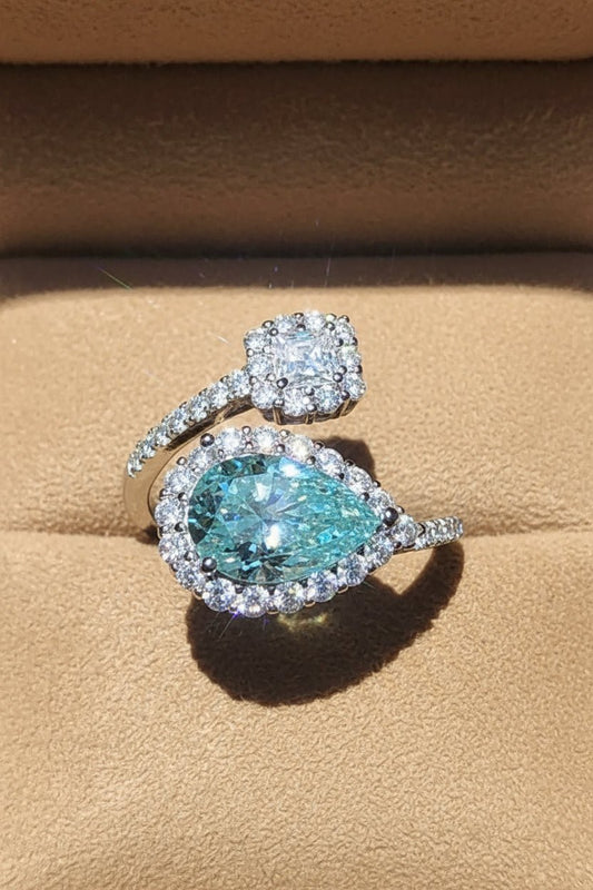 Elegant ring with a large blue gemstone and smaller moissanite stones